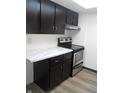 Efficient kitchen layout with black cabinets and stainless steel appliances at 3744 Tudor Park Dr # 2, Indianapolis, IN 46235