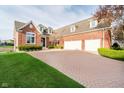 Brick home featuring an attached garage with ample parking on a brick paver driveway at 4052 Diamond Row, Greenwood, IN 46143