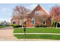 Charming brick home boasts a well-manicured lawn and flowering trees enhancing curb appeal at 4052 Diamond Row, Greenwood, IN 46143