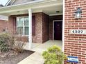 Inviting front entrance showcasing the home's brick facade, updated lighting, and a well-kept landscape at 4327 Switchgrass Way, Indianapolis, IN 46237