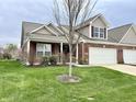 Charming single-Gathering home with brick and vinyl siding, a well-manicured lawn, and an attached two-car garage at 4327 Switchgrass Way, Indianapolis, IN 46237
