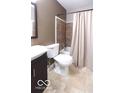 Cozy bathroom with shower-tub combination, neutral tile, and a dark wood vanity, creating a warm and inviting space at 4421 Greenmeadow Ct, Indianapolis, IN 46235