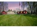 Expansive backyard with lush green grass and detached garage with American flag at 502 N Maple St, Ingalls, IN 46048