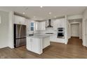 Stunning kitchen featuring a center island, white cabinetry, stainless steel appliances, and hardwood floors at 5309 Spyglass Dr, Whitestown, IN 46075