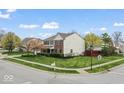 Corner lot home featuring a tidy lawn, brick accents, and an attached garage at 5817 Thompson Park Blvd, Indianapolis, IN 46237