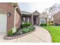 Inviting home featuring a curved walkway lined with colorful flowers and a brick facade at 6081 Boulder Ct, Columbus, IN 47201