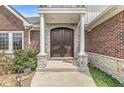 Close up of the stately stone and brick front door entry featuring a covered porch with columns at 621 Foxboro Dr, Avon, IN 46123