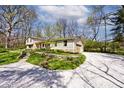 Exterior view showcasing the attached garage, stone accents, and lush landscaping at 6454 Dean Rd, Indianapolis, IN 46220