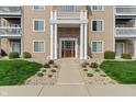Inviting condo entrance features large, white pillars, a well-manicured lawn, and easy access to numbered units at 6516 Emerald Hill Ct # 310, Indianapolis, IN 46237