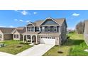 Attractive two-story house with a blue facade, a gray roof and an attached two-car garage, plus a lovely yard at 6622 Cardiff Cir, McCordsville, IN 46055