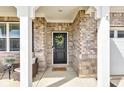 Inviting front porch featuring a black door with a green wreath and a seating area with a small table and chairs at 6622 Cardiff Cir, McCordsville, IN 46055