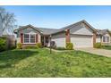 Attractive single-Gathering home with a well-manicured lawn and attached two-car garage at 7048 Tassel Meadow Dr, Indianapolis, IN 46217