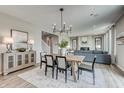 Open concept dining area with modern chandelier, wood table, and view into the spacious living room at 7331 Deerberg Dr, Indianapolis, IN 46259