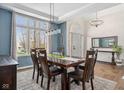 Bright dining room with large windows, an elegant light fixture, and hardwood flooring at 7424 Campfire Run, Indianapolis, IN 46236