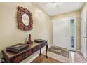 Inviting foyer with elegant decor, a wooden console table, decorative mirror, and neutral-toned walls at 7450 Deville Ct, Indianapolis, IN 46256