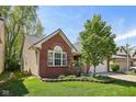 Beautiful home with a well-manicured lawn, landscaped garden, brick accents, and neutral siding at 7450 Deville Ct, Indianapolis, IN 46256