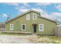 Olive green home with white trim, a gravel yard and a black front door at 7748 S State Road 39, Clayton, IN 46118