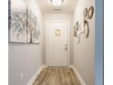 Inviting hallway with light gray walls, wood-look flooring, and decorative wall art creating a warm entrance at 7782 Rose Ln, Ingalls, IN 46048