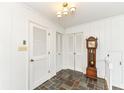 Hallway with light walls, tiled floor, wood doors, and vintage grandfather clock at 80 S Richland Ave, Carmel, IN 46032