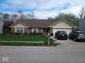 Inviting one-story home with a well-kept lawn, charming landscaping, and two-car driveway at 8106 Captain Dr, Avon, IN 46123