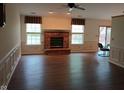 Spacious living room with a brick fireplace, hardwood floors, and natural light from large windows at 8106 Captain Dr, Avon, IN 46123