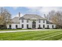 Elegant home with a grand entrance, complete with stately columns and a meticulously maintained lawn and landscaping at 8155 Hunt Club Rd, Zionsville, IN 46077