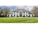 Elegant home with a grand entrance, complete with stately columns and a meticulously maintained lawn and landscaping at 8155 Hunt Club Rd, Zionsville, IN 46077