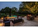 Luxurious outdoor patio with a fire feature, dining area, and comfortable seating near the pool at 8155 Hunt Club Rd, Zionsville, IN 46077