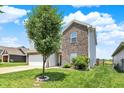 Side view of a two-story home with a well-maintained lawn and a tree in the front yard at 950 Redwood Dr, Franklin, IN 46131