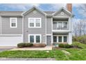 Stylish townhome with gray siding, showcasing a charming balcony and well-maintained landscaping at 1200 Shadow Ridge Rd, Carmel, IN 46280