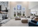 Bright living room with a floor-to-ceiling fireplace, large windows, and an open concept design at 12598 Coastal Pl, Fishers, IN 46037