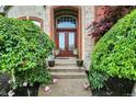 Inviting front entrance with double doors, decorative plants, and brick accents at 13758 Foxdale Lake Dr, Carmel, IN 46032