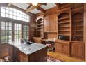 Spacious home office with built-in shelving, a large window, and a stylish desk at 13758 Foxdale Lake Dr, Carmel, IN 46032