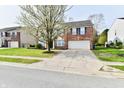 A traditional brick two-story house with a concrete driveway and a well-maintained lawn at 13858 Meadow Lake Dr, Fishers, IN 46038