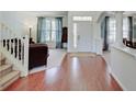 Elegant foyer with hardwood floors, staircase, and views into the living room, and dining room at 16994 Folly Brook Rd, Noblesville, IN 46060