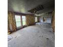 Incomplete living room restoration with exposed insulation and three windows at 1704 E Kirk St, Muncie, IN 47303
