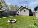 Landscaped backyard with a fire pit, a well-maintained lawn, a grill and outdoor seating in a fenced yard at 1749 E 52Nd St, Indianapolis, IN 46205