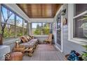 Cozy enclosed front porch with seating, windows, and a decorative door at 1917 W 58Th St, Indianapolis, IN 46228