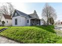 Two-story home with gray siding, inviting porch, and grassy front yard, situated on a sunny lot at 2001 S I St, Elwood, IN 46036