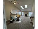 Open living room with skylights, a fireplace, and a view into the adjacent kitchen at 2344 Orchard Creek Dr, Columbus, IN 47201