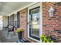 Close up of a welcoming front porch with decorative plants, a stylish door, and brick accents at 241 Green Meadow Dr, Indianapolis, IN 46229