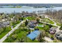 Stunning aerial view of estate featuring a pool, tennis court, and lush landscaping near the lake at 290 Breakwater Dr, Fishers, IN 46037