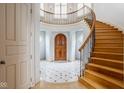 Elegant foyer with curved staircase, wood front door, and marble floors at 290 Breakwater Dr, Fishers, IN 46037
