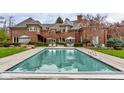 Gorgeous backyard pool with lounge area and umbrellas, complemented by a classic brick home at 290 Breakwater Dr, Fishers, IN 46037