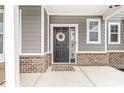 Welcoming front door with stylish wreath, complemented by charming brickwork and cozy porch decor at 474 Pekin Way, Pendleton, IN 46064