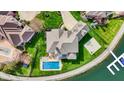 Aerial view of a lakefront home with a pool, basketball court and pristine lawn at 4883 Snowberry Bay Ct, Carmel, IN 46033
