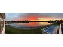 Panoramic view of the lake at sunset with a swimming pool in the foreground at 4883 Snowberry Bay Ct, Carmel, IN 46033