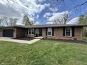 Charming brick home featuring a well-maintained lawn and a dark-colored two-car garage at 4912 Cayman Ct, Columbus, IN 47203