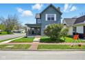 Charming two-story home with a covered porch and sidewalk and a well-maintained front yard at 516 S 10Th St, Noblesville, IN 46060