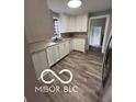Bright kitchen featuring wood floors, white cabinets, and neutral countertops at 517 Dicks St, Lebanon, IN 46052